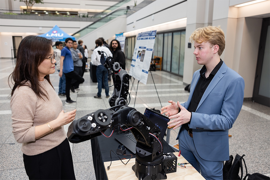 Dean Choe speaking with Seaver student at Design Showcase